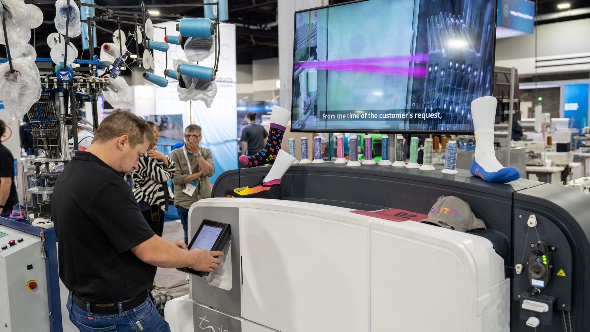 Attendees exploring diverse textile designs at a booth during Texworld New York.